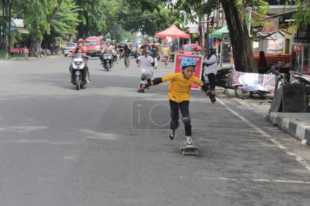 Téléchargez les photos : Un homme asiatique monte sur un skateboard dans la rue lors de la célébration de la journée de skateboard. Indonésie - Medan, 21 juin 2024 - en image libre de droit