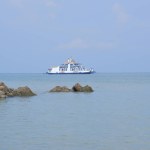 A White Ferry Is Anchored In The Middle Of The Sea On The Coast Of Tanjung Kalian, Indonesia