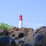 Large Natural Rocks Set Against The Lighthouse Tower Of Tanjung Kalian, Indonesia