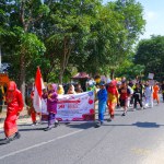 MUNTOK,INDONESIA - SEPTEMBER 10, 2023 : Elementary School Student Carnival Participants Carrying Banners At The Commemoration Of The Independence Day Of The Republic Of Indonesia