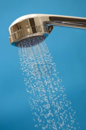 a closeup view of a shower head holding a silver crystal clear water in a bathroom 