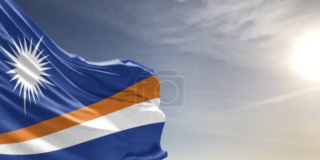Téléchargez les photos : Tissu drapeau national des Îles Marshall agitant sur beau ciel gris Arrière-plan. - en image libre de droit