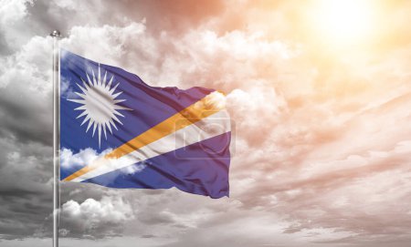 Téléchargez les photos : Tissu drapeau national des Îles Marshall agitant sur beau fond gris nuageux. - en image libre de droit