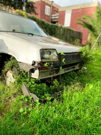 Foto de Vehículo viejo abandonado, envejecido y cubierto de hierba - Imagen libre de derechos