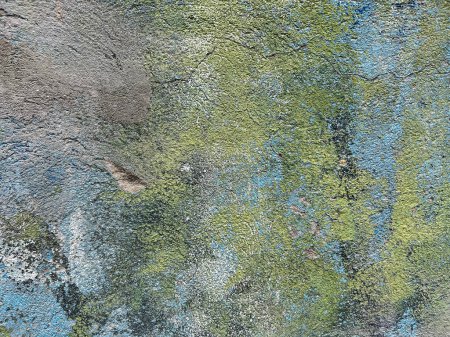 Foto de El viejo muro de hormigón y cemento está cubierto de grietas, moho verde y restos de pintura azul. Textura, textura, fondo, vista frontal - Imagen libre de derechos