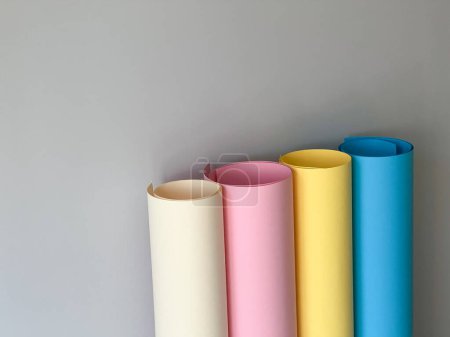 Foto de 4 rollos de papel de colores sobre un fondo sencillo. Amarillo, azul, beige, rosa - Imagen libre de derechos