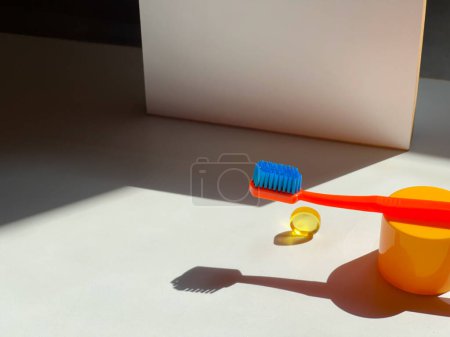 Foto de Colorido cepillo de dientes de naranja y dulces. Naturaleza muerta. Cuidado dental. Rutina matinal - Imagen libre de derechos