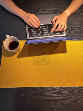 Foto de Trabajar de forma remota desde cualquier parte del mundo: la persona escribe en el teclado, vista desde arriba, en la mano se ve la huella bronceada del reloj - Imagen libre de derechos