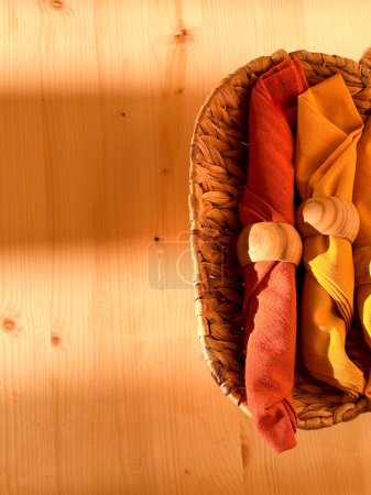 Textile Servietten in einem Korb auf einem Holztisch. Gemütliche Details zu Hause. Licht und Schatten