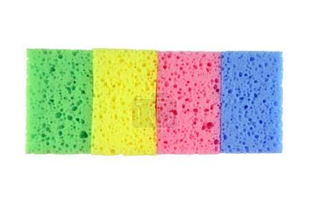 Foto de Un grupo de esponjas de lavado nuevas (amarillo, rosa verde y azul) que yacen en una fila (línea), aisladas - Imagen libre de derechos