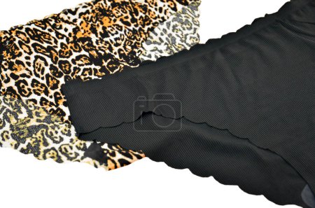 Nahtlose Damenunterwäsche (Dessous, Höschen, Slip) aus schwarzem und Leopardenmuster mit gewelltem Rand isoliert, Vorderseite von oben