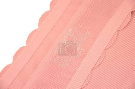 Peach rosa sin costuras (invisible) ropa interior de mujer (lencería, bragas, calzoncillos) con borde ondulado aislado primer plano con una etiqueta impresa en el interior
