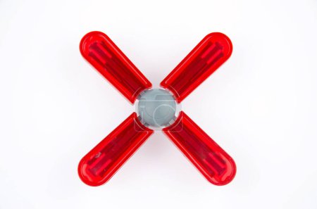 Rotes Rotorsystem des Spielzeughubschraubers aus Kunststoff isoliert auf weißem Hintergrund, Nahaufnahme, Draufsicht