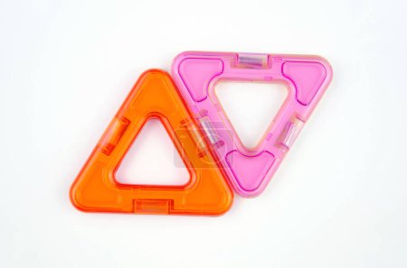 Two plastic triangles from transparent magnet constructor kit (puzzle builder for kids) isolated on a white background