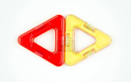 Two plastic triangles from transparent magnet constructor kit (puzzle builder for kids) isolated on a white background