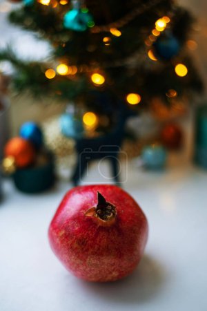 Foto de Vista de cerca de la granada sobre fondo borroso con decoración navideña. Concepto de Navidad - Imagen libre de derechos