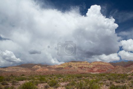 Téléchargez les photos : Paysage désertique. Vue sur la terre aride et les montagnes colorées sous un beau ciel dramatique avec des nuages blancs. - en image libre de droit
