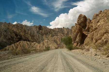 Foto de Camino de tierra a través del desierto. Conducir a través de la carretera rural en el valle de la muerte y las montañas rocosas. - Imagen libre de derechos