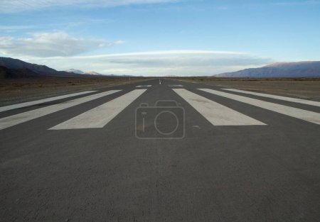 Photo for Travel. Wide straight asphalt airdrome road across the desert and into the mountains. - Royalty Free Image