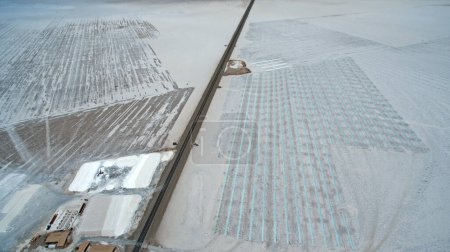 Foto de Sal natural plana. Industria. Vista aérea aérea de la carretera de asfalto a través de las minas de sal y lagos de sal artificiales. - Imagen libre de derechos