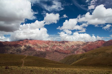 Foto de Las famosas montañas de colores Hornocal en Humahuaca, Jujuy, Argentina. La ruta de senderismo a través de la pradera dorada y colinas, en la cordillera. Hermosos colores de piedra y textura. - Imagen libre de derechos