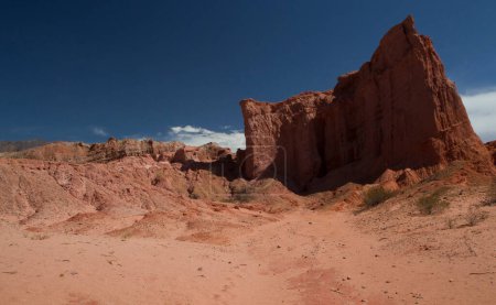 Foto de El árido desierto. Vista de la arena roja, arenisca y formaciones rocosas bajo un cielo azul. - Imagen libre de derechos