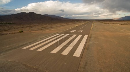 Photo for Travel. Aerial view of a wide asphalt aerodrome road in the arid desert and Andes mountains. - Royalty Free Image