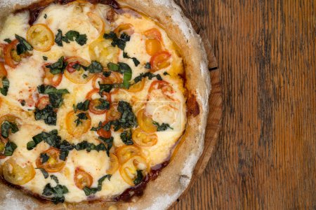 Téléchargez les photos : Pizza avec mozzarella et provolone, ail et tomates cerises. - en image libre de droit