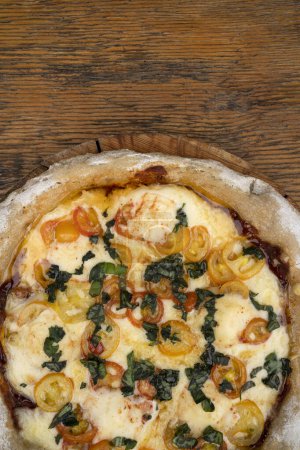 Téléchargez les photos : Pizza avec mozzarella et provolone, ail et tomates cerises. - en image libre de droit
