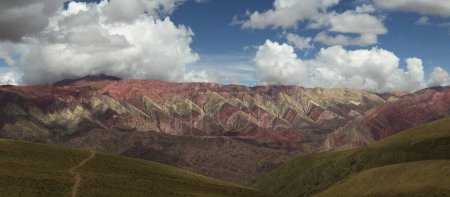Photo for The famous Hornocal colorful mountains in Humahuaca, Jujuy, Argentina. The hiking path across the golden meadow and hills, into the mountain range. Beautiful stone colors and texture. - Royalty Free Image