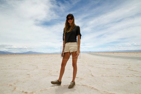Photo for Tourism. Portrait of young adult caucasian woman in the white salt desert. Blond tourist wearing sunglasses in the salt flats under a beautiful sky. - Royalty Free Image