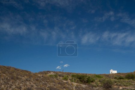 Téléchargez les photos : Belle vue sur une petite chapelle blanche au sommet de la montagne sous un ciel bleu profond. - en image libre de droit