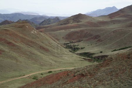 Foto de Valle encantado en Salta, Argentina. Vista de los pastizales, colinas, valle y camino de tierra a través del campo verde. - Imagen libre de derechos