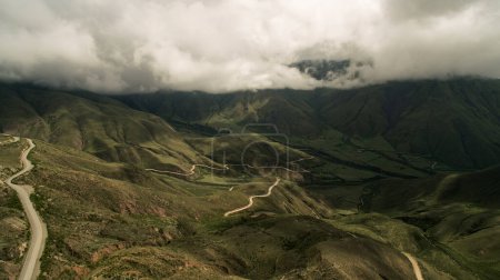 Photo for Adventure. View of the curved road across the popular landmark Cuesta del Obispo. The grassland, valley and hills under a dramatic cloudy sky. - Royalty Free Image