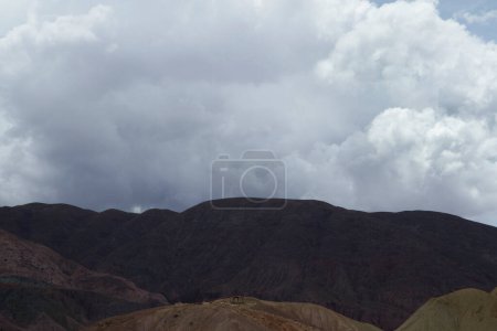 Photo for Inspirational natural background for quotes. Cloudscape. View of the arid mountain range peaks under a beautiful white and cloudy sky. - Royalty Free Image