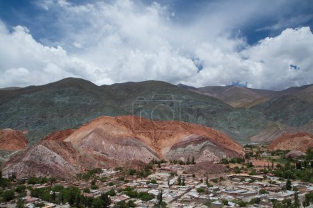Photo for Altiplano landmark and popular destination. Aerial view of the village Purmamarca at the foot of the Seven Color Hill in Jujuy, Argentina. The town buildings and colorful mountains in a clear day. - Royalty Free Image