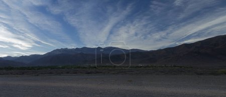 Photo for Beautiful sunrise in the mountains. Panorama view of the dirt road along the desert and Andes mountain range with beautiful dawn colors under a deep blue sky - Royalty Free Image