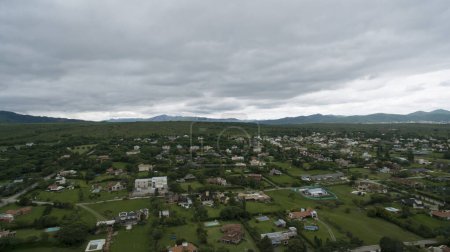 Foto de Vista aérea de las casas rurales y el campo al pie de las montañas, durante el atardecer. - Imagen libre de derechos