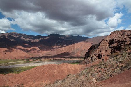 Photo for Desert landscape. Geology. View of the beautiful green valley surrounded by the red canyon called Three Crosses and mountains under a blue sky in Salta, Argentina. - Royalty Free Image