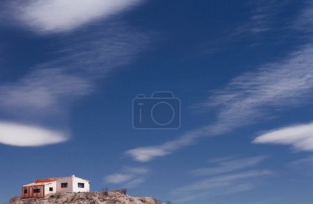 Téléchargez les photos : Vue spectaculaire d'une maison au sommet de la montagne et du ciel céleste avec de beaux nuages. - en image libre de droit