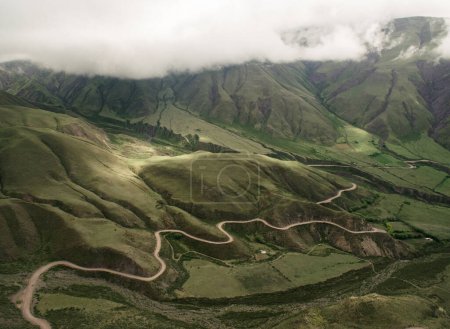 Téléchargez les photos : Vue aérienne de la Cuesta del Obispo à Salta, Argentine. Route courbe le long de la pente de la montagne, couverte d'herbes vertes. - en image libre de droit