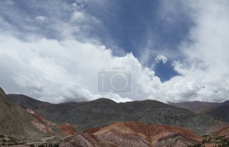 Foto de Las coloridas colinas bajo un cielo dramático. Vista aérea de las hermosas montañas andinas en Purmamarca, Jujuy, Argentina. Los hermosos minerales colores y texturas y patrones rocosos. - Imagen libre de derechos