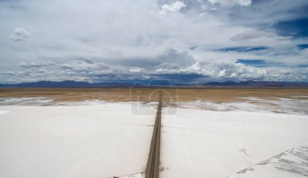 Photo for Salt industry. Aerial view of the natural salt flat and highway across the mines and salt pools, into the desert mountains. - Royalty Free Image