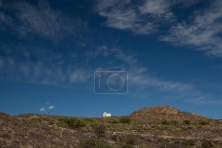 Téléchargez les photos : Maison de Dieu. Vue allégorique d'une petite chapelle au sommet d'une montagne sous un beau ciel bleu profond. - en image libre de droit