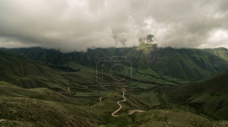 Foto de Vista aérea de la Cuesta del Obispo en Salta, Argentina. Camino curvo a lo largo de la ladera de la montaña, cubierto de hierbas verdes. - Imagen libre de derechos
