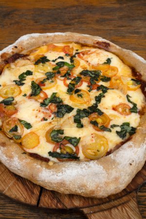 Foto de Vista de cerca de una pizza con queso mozzarella y provolone, ajo y tomates cherry. - Imagen libre de derechos