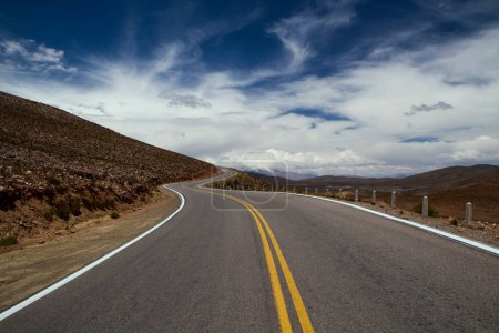 Téléchargez les photos : Escapade. Vue artistique de la route asphaltée à travers le désert et les collines sous un ciel dramatique. - en image libre de droit