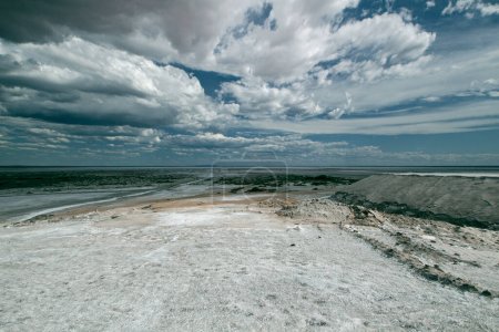 Natural Salt flats. Industry and Salt mining. Saltworks and salt natural fields under a dramatic and stormy sky