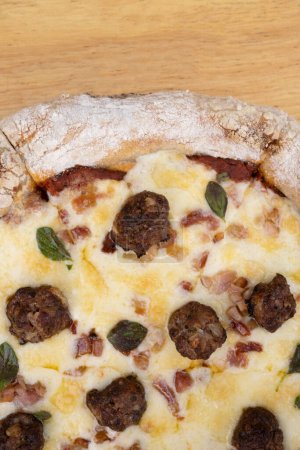 Foto de Vista de cerca de una deliciosa pizza con queso mozzarella, tocino crujiente, salsa de tomate y albóndigas. - Imagen libre de derechos
