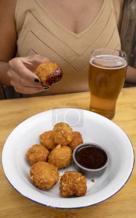 Photo for Closeup view of fried chicken balls with a spicy sauce in a white bowl. - Royalty Free Image